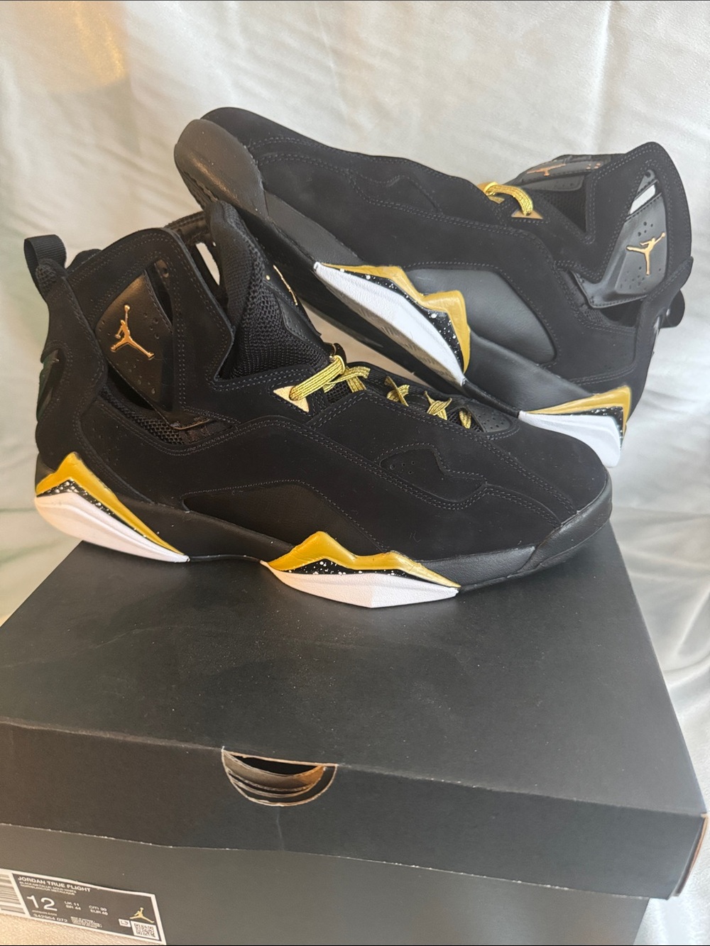 Nike Jordan True Flight sneakers in a Black Metallic Gold White colorway.